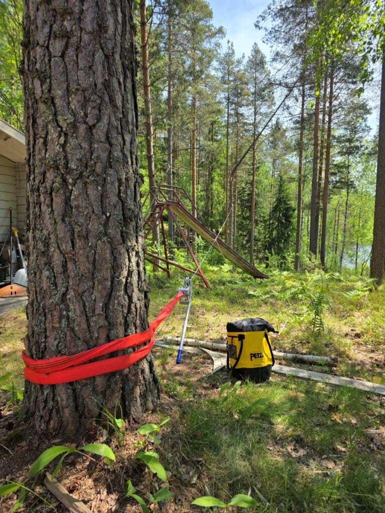 Keskeltä lahonnut ja toisen puun varaan konkeloon jäänyt vaarallinen puu kesämökin läheisyydessä Salon Kiskossa. Murtunut runko nojaa viereisen puun oksistoon aivan mökkirakennuksen vieressä.